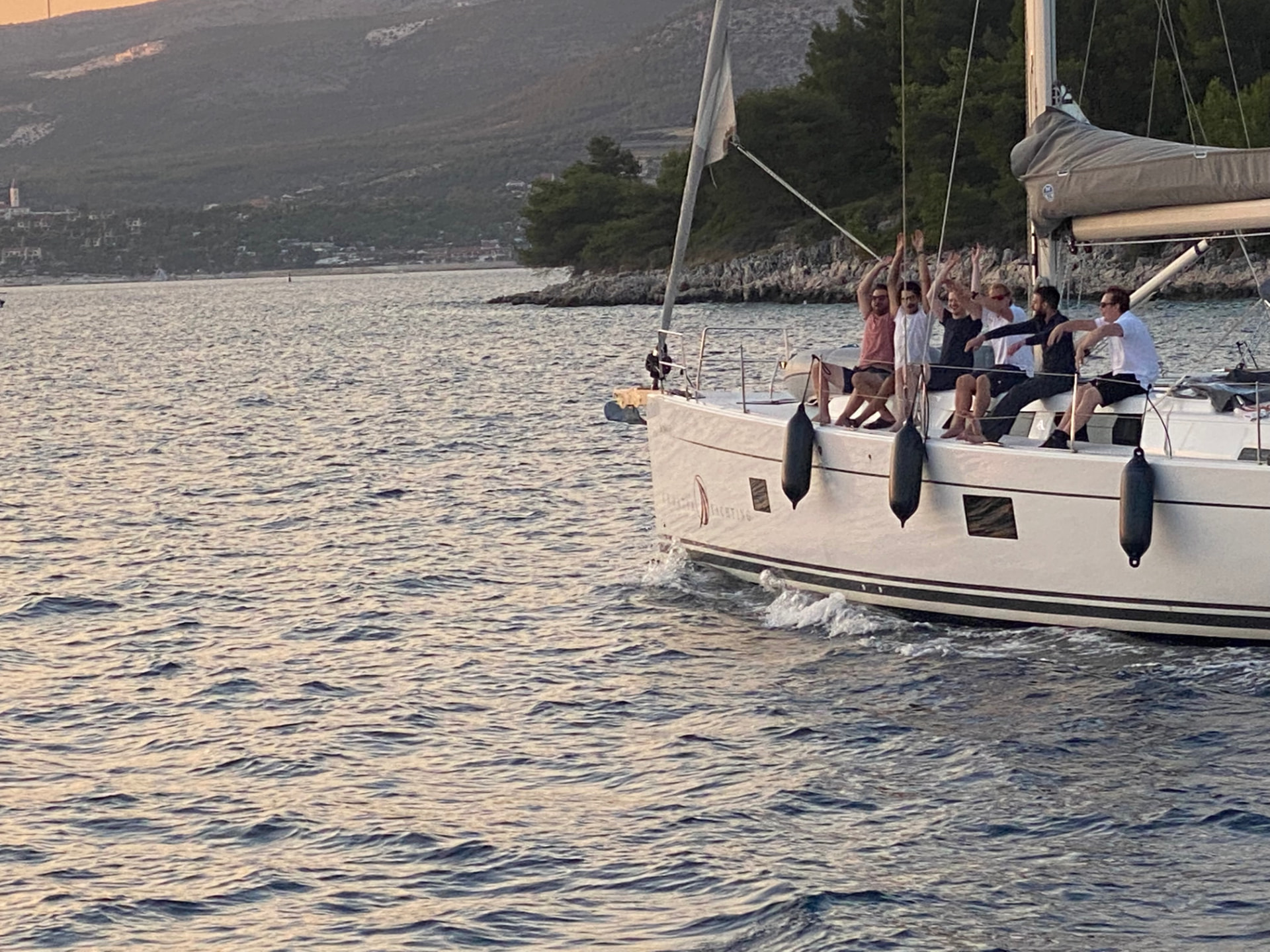 Blue Partner-kollegor vinkar från segelbåten i solnedgången